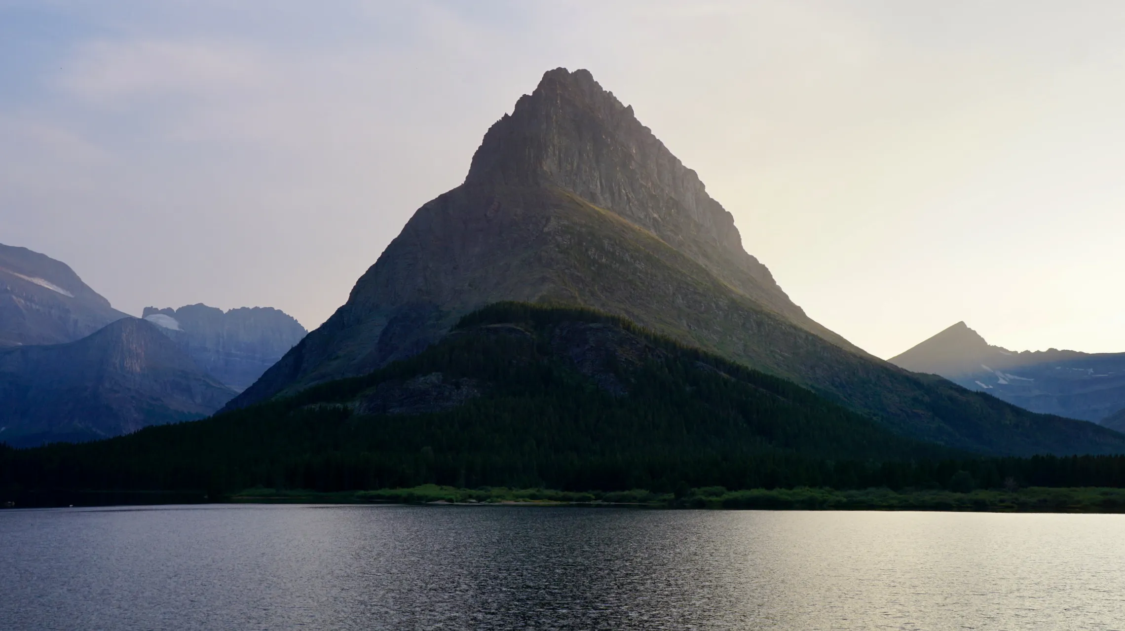 A majestic peak illuminated by the soft glow of the waning sun at Glacier National Park